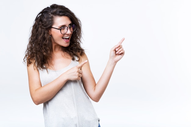 Beautiful young woman showing and pointing over white background. Free Photo